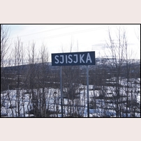 Sjisjka hållplats den 14 maj 2016. Sjisjka är "berömt" för att namnet innehåller SJ två gånger. I bakgrunden syns del av den stora vindkraftpark som tillkommit på senare år. Foto: Hans Isachsen. 