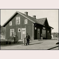 Mjöbäck station 1959, sista sommaren innan banan lades ned. Rälsbussföraren Axel Ekelund får själv fälla bommarna. Foto: Okänd. 
