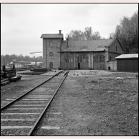 Åtvidaberg station den 6 maj 1972. Lokstallet byggdes 1905 och inrymde som syns på portarnas storlek två stallrum för smalspåret (Norsholm - Åtvidaberg - Västervik) och ett för normalspåret (Bjärka-Säby - Åtvidaberg). Vändskivan som på smalspårstiden givetvis var fyrspårig hade en diameter av 15 m. Under ett antal åt på 1960-talet hyste stallet det gamla elektroloket Pa 27, numera på Sveriges Järnvägsmuseum i Gävle. I bakgrunden ser man ÅSSA (Åtvidabergs Spårväxlar och Signalfabriks AB), ett i järnvägskretsar välkänt företag. Stallet revs 1993.  Foto: Jöran Johansson. 