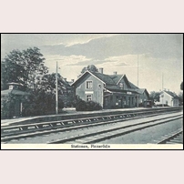 Finnerödja station på ett vykort postgånget 1928. Den ljusa byggnaden bortom stationshuset är bostadshus 9B. Mellan dessa två byggnader skymtar stinsbostaden. Foto: Okänd. 