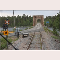 Bro över Piteälven den 1 juli 2011, foto från söder. Bommarna för landsvägen har fällts av motorvagnsföraren sedan han konstaterat att ingen annan trafik finns på bron. Foto: Olle Thåström. 