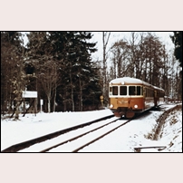 Gräfsnäs slottspark den 19 april 1969. Den reguljära trafiken pågår ännu ett år, men själva hållplatsen är nedlagd sedan två år tillbaka. Här passerar SJ:s rälsbuss YBo5p 922 den nedlagda hållplatsen. Bild från Sveriges Järnvägsmuseum. Foto: Okänd. 