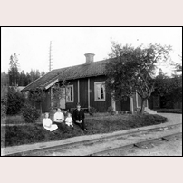 Gårdsjö hus 9A, före detta banvaktsstuga med okänt nummer. Bilden visar stationskarlen Ernst Haglund med hustru och två döttrar. Flickorna är födda 1911 och i november 1913 varför man kan fastställa fotoåret till 1915. Bild från Mariestad & Töreboda bildarkiv. Foto: Erik  Rud. 
