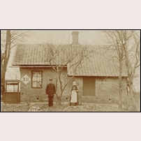 311 Ormanäs okänt år efter 1908. Med all sannolikhet är det banvakten Anders Andersson och hans hustru Stina Maria som poserar utanför stugan. Andersson var banvakt här mellan 1905 och 1910. Det skulle betyda att bilden är tagen 1909 eller 1910. Foto: Okänd. 