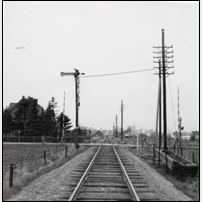 735 Tommarp syns inte på bilden, den låg till höger efter korsningen men hade nyligen rivits. I fjärran syns bakdelen av ett rälsbusståg inne på stationen. Bilden är tagen i november 1957. Foto: Okänd. 