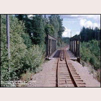 Bro över riksväg 31 nordost om Norrhult medan den fortfarande var en järnvägsbro. Snart ska den pensioneras, bilden är tagen den 18 augusti 1984, två dagar innan trafiken läggs ned. Foto: Björn Elthammar. 