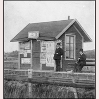 Lödöse station i början av 1900-talet. På de tidstypiska reklamskyltarna kan man bl.a. läsa Söderfors Bruk och Mazetti Cacao. Bild från Järnvägsmuseet. Foto: Okänd. 