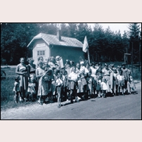 Hynboholm hållplats i juni 1953. Barn och mammor har samlats i väntan på att kungen skall passera på sin Eriksgata genom Värmland. Och så fick hållplatsen för en gångs skull komma med på en bild. Bilden hämtad från Facebookgruppen Gamla fotografier av Karlstad. Foto: Okänd. 