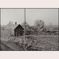 509 Säby den 27 maj 1960. Det är den högra stugan som avses. Bortom stugan syns infartssignalen (semafor) på linjen från Billesholm till Säby station. Spåret till vänster är den 2,4 km långa Säbyholms järnväg som utgick från Säby station till Säbyholms sockerbruk. Foto: Okänd. 