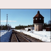 Nederhögen station den 11 april 1981. Invid norra utfarten ligger ett väldigt trevligt vattentorn. Mellan spåren står också den gamla vattenhästen kvar. I bakgrunden ses ett beredskapsstall för ånglok. Foto: Jöran Johansson. 
