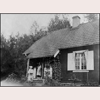 108 Kallhäll 1936.
Ur Järfälla kommuns bilddatabas: 
"Banvaktstugan mellan Kallhäll och Stäket. På bilden syns banvaktare Karlssons hustru Agda med vitt huckle framför stugan. På verandan står dottern Siri med katten Pärlan i famnen och hunden Bella ligger på trappan. Stinsen Malcom Berggren och hans hustru Anna-Lisa dog 1922 (hon i februari, han i september). Dottern Lisa blev då placerad hos familjen Karlsson ett par år. Hon blev också flyttad från Kallhälls skolan till Stäketskolan." Foto: Maria Ekholm, Sundbyberg. 