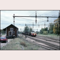 Munkfors station den 24 september 1990. Lok 103 ankommer från söder med godståg 9352 bestående av enbart överföringsvagnar med upplastade normalspåriga vagnar. Foto: Bengt Gustavsson. 