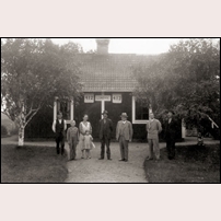412-413 Lundvik omkring 1930. Från vänster ses banvakten Nils-Olof Svensson (f. 1882) med sonen Erland (f. 1919), hustrun Signe (f. 1895) och dottern Stina (f. 1926). Sannolikt bodde familjen Svensson i denna stuga då bilden togs. Därefter Nils Håkansson (f. 1888) och Martin Backéus (f. 1878) med sonen Evald (f. 1903). Backéus hade varit banvakt i Nyhem från 1903 till omkring 1907, då han övergick till att bli handlande. Det är inte klarlagt i vilken stuga familjen Backeus bodde; det måste alltså inte ha varit i just denna. Längst till höger Per Håkansson (f. 1886, bror till Nils Håkansson). Bröderna Håkansson var hemmansägare från den närbelägna gården Moarna. Deras syster Engla Elisabet var gift med Martin Backeus. Bild från Nyhems Bygdehistoriska Förening.

 Foto: Okänd. 