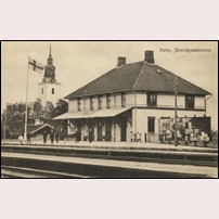 Heby station på 1910-talet. I bakgrunden sockenkyrkan Västerlövsta. Bild från Järnvägsmuseet. Foto: Okänd. 