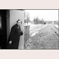 Luleälvsbron var till 1975 en kombinerad järnvägs- och landsvägsbro. Den måste därför vid varje tågs passage stängas för landsvägstrafik. Den sista brovakten här var fru Aina Eriksson (1918-2013) som var bosatt i den intilliggande banvaktsstugan. Här väntar hon 1973 i manöverkuren söder om bron på ett godståg från Jokkmokk mot Gällivare. Hon höll kontakt med fjärren på telefon från banvaktsstugan eller i kuren för att kolla om tåget var i tid. När tåget närmade sig och det var dags att fälla bommarna så hördes en summerton i kuren. 

Bild från Järnvägsmuseet. Foto: Seved Walther. 