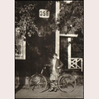 358-359 Kallkällan omkring 1929. Bilden är ett bidrag från Eva Widebro och det är hennes mamma May som poserar med sin cykel under nummerskylten (den ena av husets två). Foto: Okänd. 