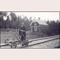 16 Käringagärde 1929 med banvakten Klas Johansson Lindén. Dressinen verkar vara ett hembygge där en gammal cykel kommit till användning i samarbete med en trehjulig tralla med träram. Bild från www.kvarnabo.eu. Foto: Okänd. 