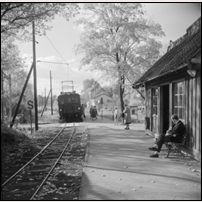 Stockby hållplats omkring 1961. Hållplatsen har  av någon anledning plattform på båda sidor om vägövergången. Bortåt i bild är mot Stocksund. Bild från Sveriges Järnvägsmuseum. Foto: Lennart Welander. 