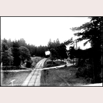 Lilla Mon kombinerade hållplats- och banvaktsstuga ligger inbäddad i grönskan till vänster. När bilden är tagen är inte känt. Bild från Järnvägsmuseet. Foto: L.W. Andersson. 