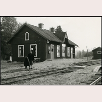 Ätrafors station 1959, året då banan skulle komma att läggas ned. Här vevar platsvakten Elvy Bengtsson bommarna.  Foto: Okänd. 