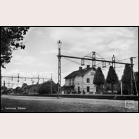 Vallberga station på 1940- eller 1950-talet. Till vänster om stationshuset ligger först ett godsmagasin, därefter ett privatägt magasin och längst till vänster syns den höga skorsten vid Vallberga välkända mejeri, tyvärr nedlagt (1991). Vykort på bild från Järnvägsmuseet. Foto: Bertil Zell. 