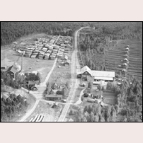 Kroksbo håll- och lastplats på 1960-talet. Till vänster ligger ett sågverks och till höger en torvströfabrik med sitt "upptagningsområde". Fotoriktning mot söder. Bilden hämtad från Facebookgruppen Järnvägar förr och nu. Foto: Okänd. 