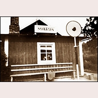 Myråsen hållplats på 1940-talet. En enkel soffa med ryggstöd spikat direkt på väggen bidrar till de resandes bekvämlighet. Bild från Västergötlands museum. Foto: Okänd. 