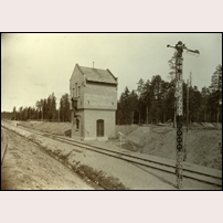 Klutmark station, vattentornet är av en modell som uppfördes i stort antal. Tyvärr är de flesta av dessa karaktärsbyggnader rivna, så ock denna i Klutmark. Bilden uppges vara tagen omkring 1910 (tornet byggdes 1912). Bild från Järnvägsmuseet.  Foto: Okänd. 
