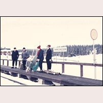 Timmerkojan hållplats troligen 1958. Bilden är ett bidrag från Tommy Sjölander och har tidigare varit utlagd i Facebookgruppen Gamla bilder från Åre och västra Jämtland, där Tommy skriver: "Familjerna Sjölander och Dahlgren står och väntar på rälsbussen vid hållplatsen Timmerkojan för färd mot Storlien. Året är troligen 1958. Barnet mitt i gruppen är undertecknad. Pappa John tog bilden.
- - - - - 
Vid tillfället hade rälsbussen inte något stopp vid Timmerkojan. Däremot gick det tydligen för sig att man kom överens med föraren att han passerade hållplatsen sakta. Mycket sakta, men utan att stanna. För det fick han inte. Alltså, utan att stanna öppnades dörren i farten, barn, ryggsäckar, pulkor och skidor langades in i rälsbussen, som obevekligen rullade vidare längs perrongen. Det lär ha varit en nervpirrande och andlös cirkus med höga insatser. Så gick det till 1958. 
Mamma Dorith berättade. Foto: John Sjölander. 