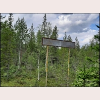 Gränsen Värmland - Dalarna den 4 juli 2025. Med stor svårighet kan man läsa att texten slutar med NA vilket visar att skylten står på den västra sidan av järnvägen. Foto: Björn Wåhlin. 