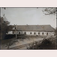 Dalkarlsberg station omkring 1900. Den här stora byggnaden innehöll järnvägsstation, reparationsverkstad, lokstall och betjäningsbostad, den hade tidigare varit järnvägsmagasin för Dalkarlsbergs bruk. (Uppgifterna liksom bilden är hämtade från Järnvägsmuseet). Foto: Okänd. 