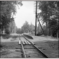 Knutstorp hållplats på 1960-talet. Utöver en plattform med betongkant finns här ingenting av det som brukar finnas även på de mest anspråkslösa trafikplatser, ingen påstigningstavla, ingen sittplats, ingen tidtabell och förstås ingen belysning. Men en lastbrygga, eller vad det kan vara lite väl långt från spåret? Bild från Järnvägsmuseet. Foto: Sven Ove Lundberg. 